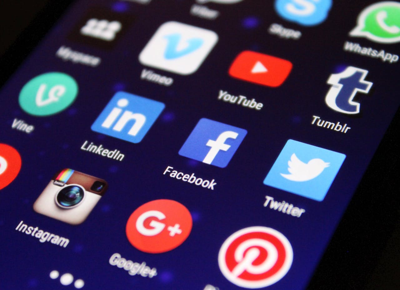 services-04 Close-up of a smartphone screen showing various social media app icons such as Facebook and Twitter.